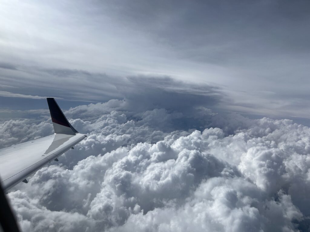 A view of the wing and clouds from an airplane.