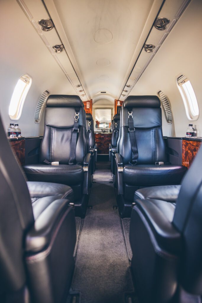 A small airplane with black leather seats and white walls.