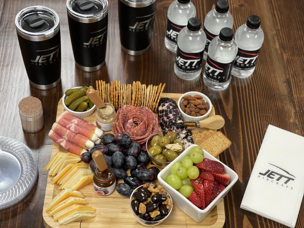 A wooden board with various foods and drinks on it.