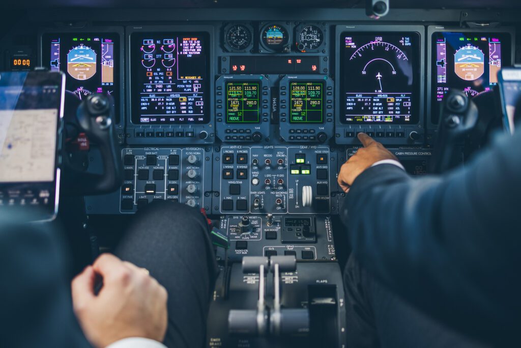 A person is sitting in the cockpit of an airplane.