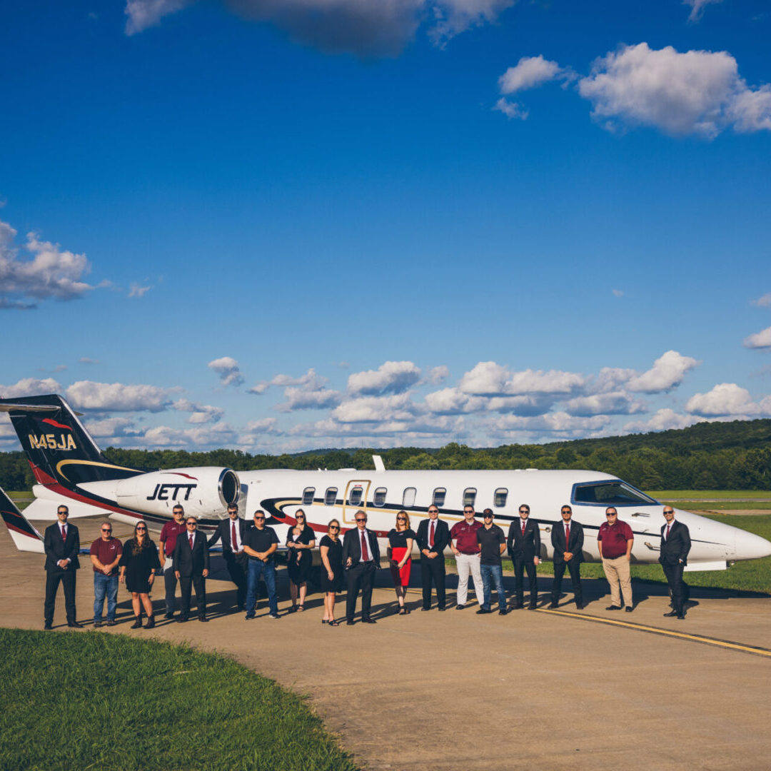 A group of people standing around an airplane.